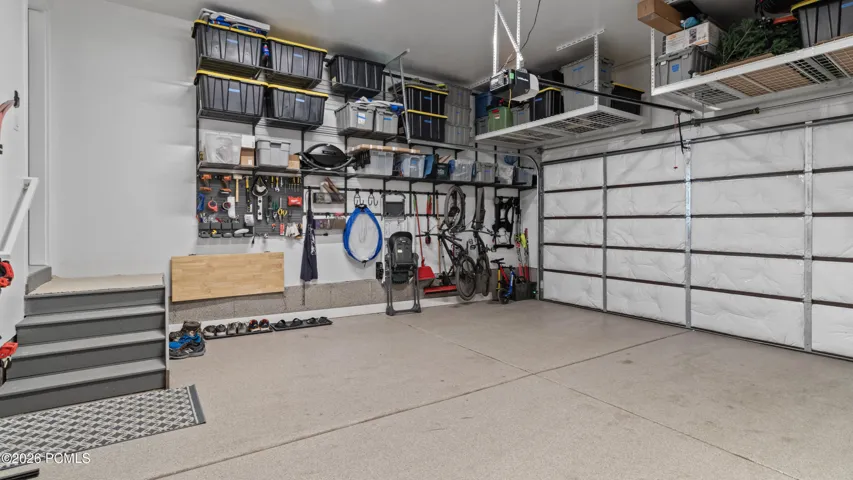 Two car garage with built in storage, a foldup work bench, and a storage closet. Wired for EV charging.