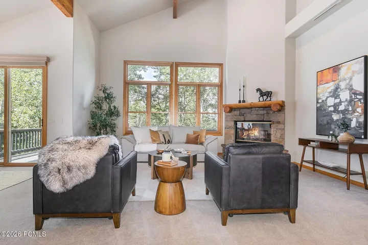 Dramatic high-volume ceiling accented by warm wood beams, creating an inviting sense of space and architectural character.