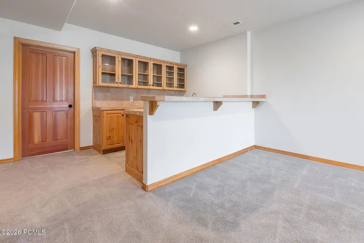 Lower-level bar or kitchenette adds convenience for entertaining, guests, and everyday flexibility.