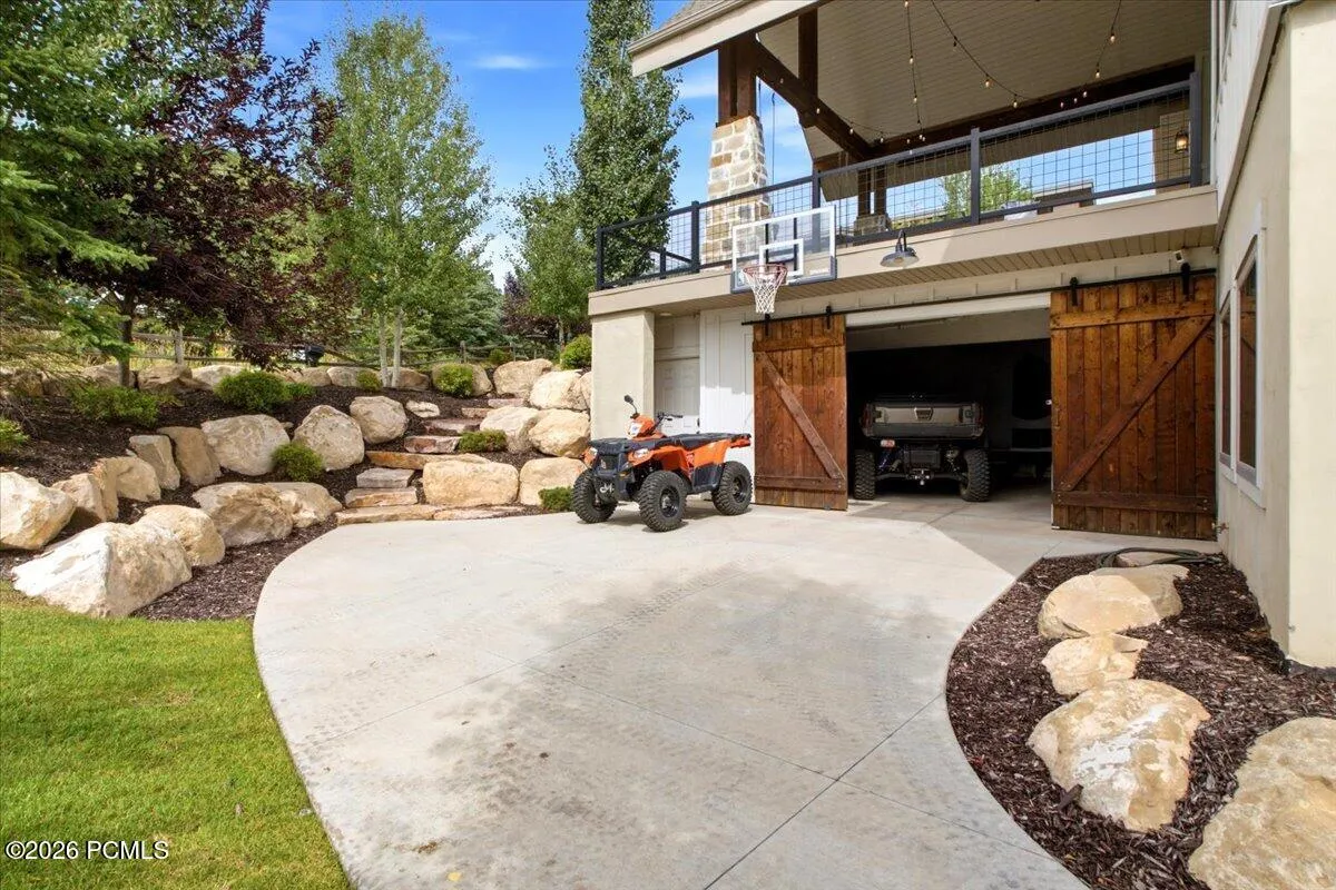 Lower-level garage featuring two large barn-style doors and a concrete driveway