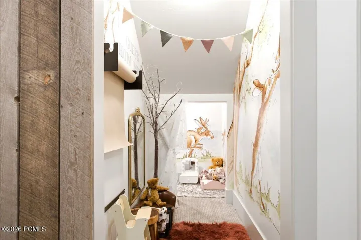 Play room under the stairs featuring hand painted wall mural