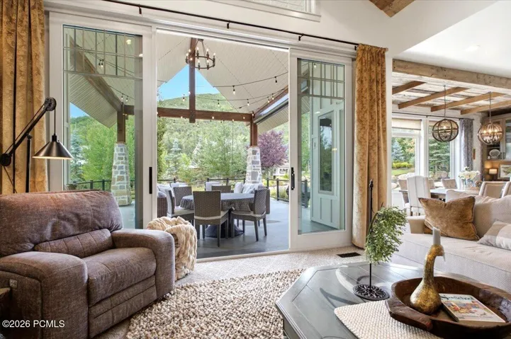 Living area featuring expansive sliding glass doors opening to a covered outdoor patio