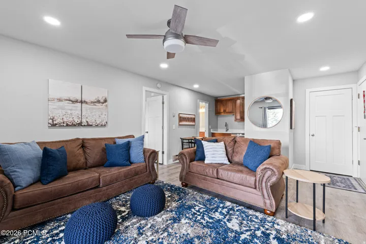 Living area with light wood finished floors, ceiling fan, and recessed lighting