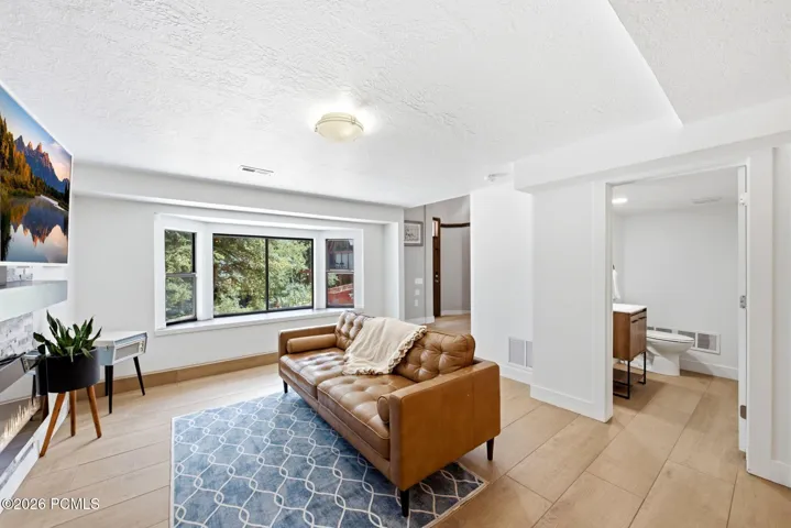 Light-filled living area featuring a prominent bay window, and half bath