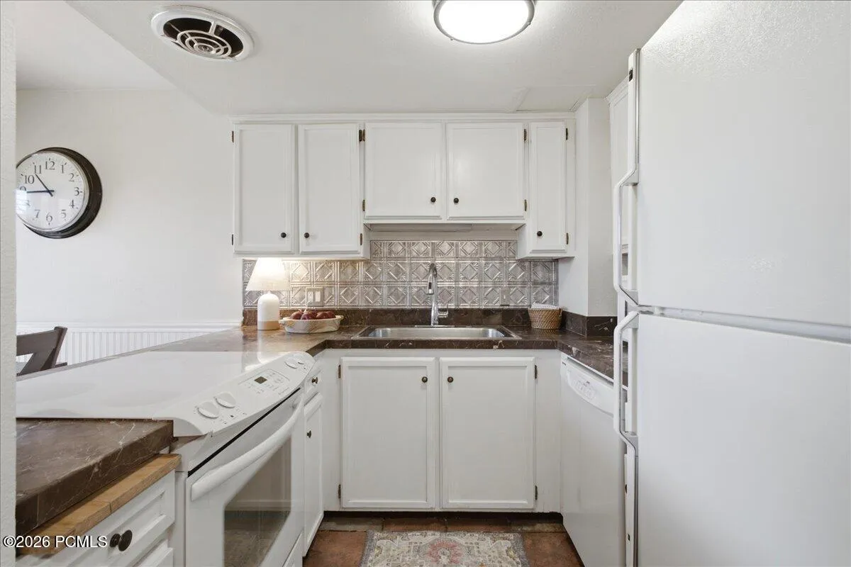 Functional Kitchen with bright white cabinetry.