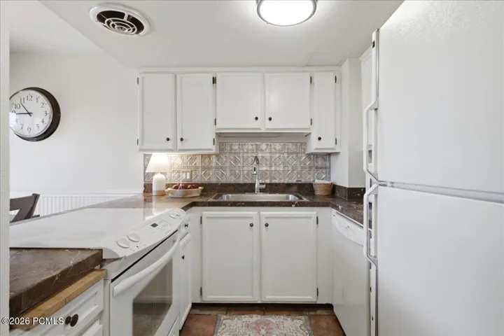 Functional Kitchen with bright white cabinetry.