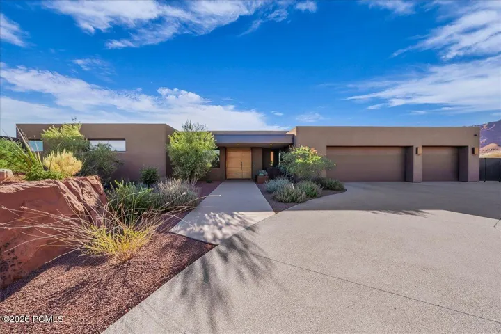 Modern desert architecture featuring a flat roofline and integrated three-car garage