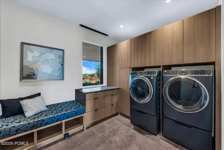 Laundry room featuring a built-in bench and custom wood cabinetry