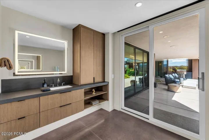 Primary Bathroom with dual vanities and sliding glass door leading to the pool and spa area