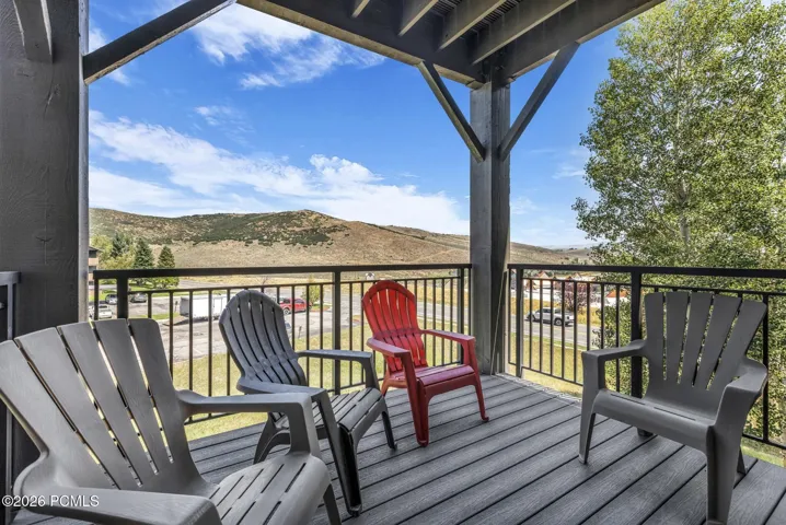 Outdoor balcony featuring all new composite decking, black metal railings, and structural wood beams which are also new.