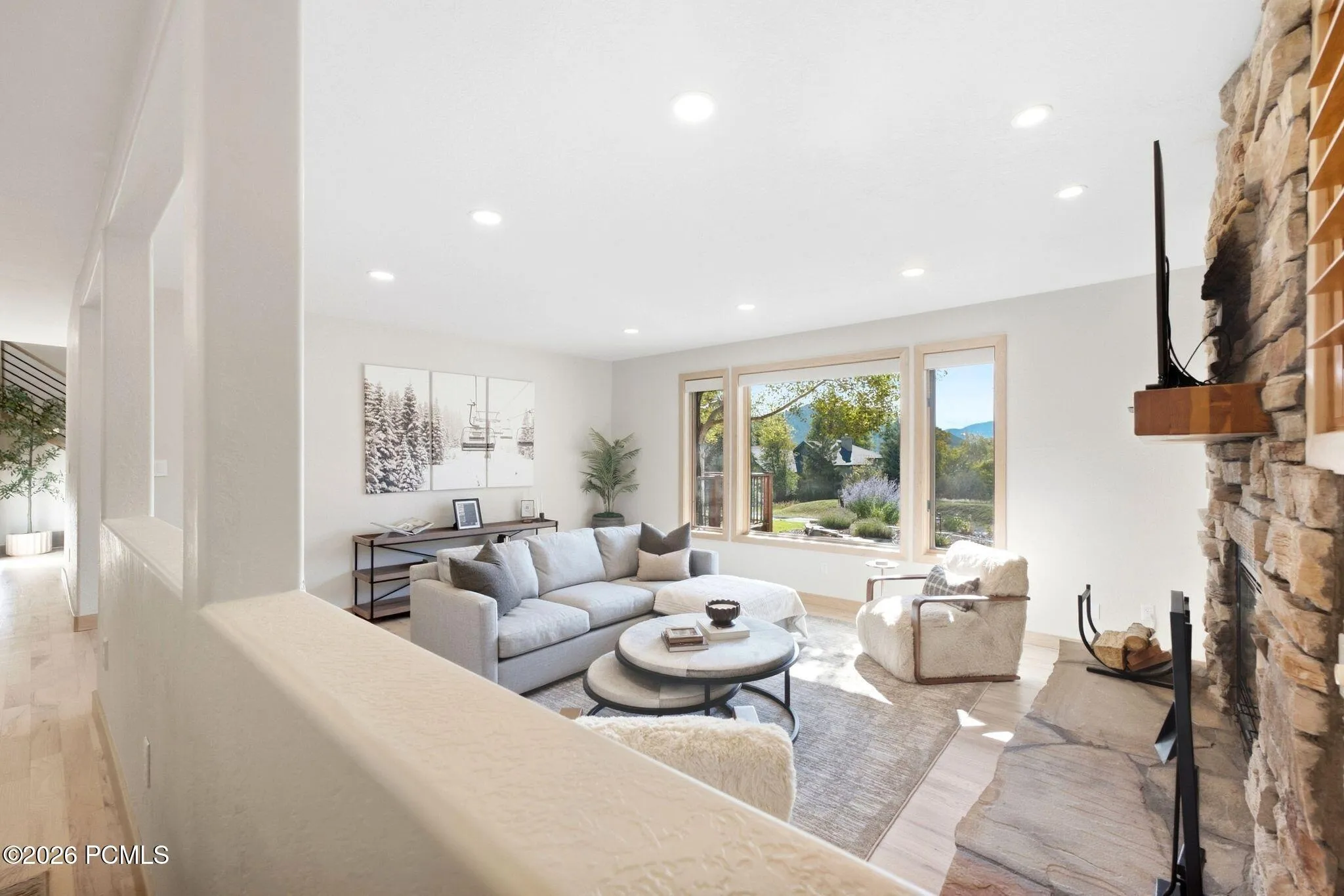 Open concept kitchen, dining, and living area. Refinished wood flooring throughout, updated lighting, wood-framed windows with wooden shutters, natural light and views.