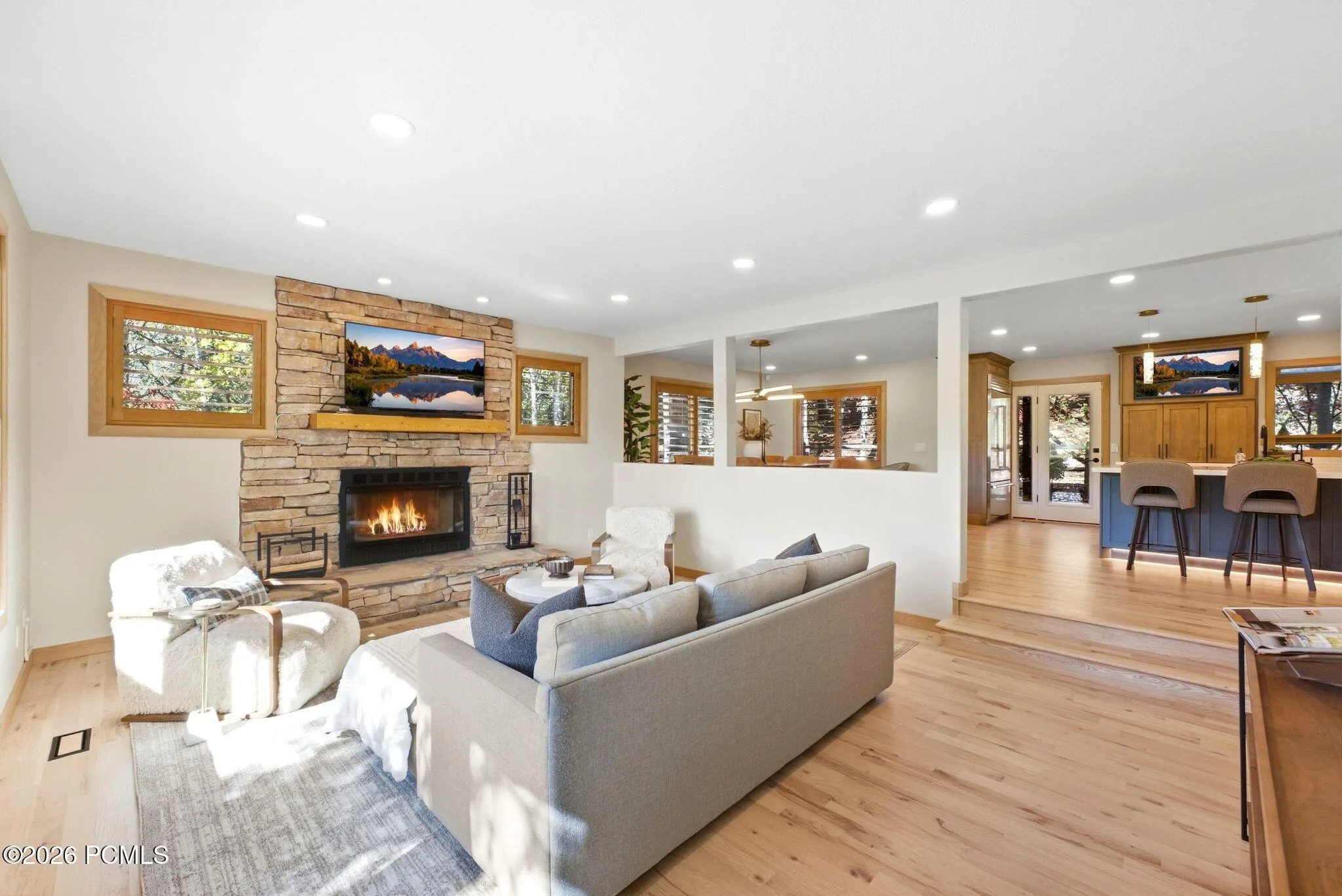 Open-concept living area featuring refinished hardwood flooring, updated recessed ceiling lighting, with ample natural light and a picture window that brings Park City into your living room.
