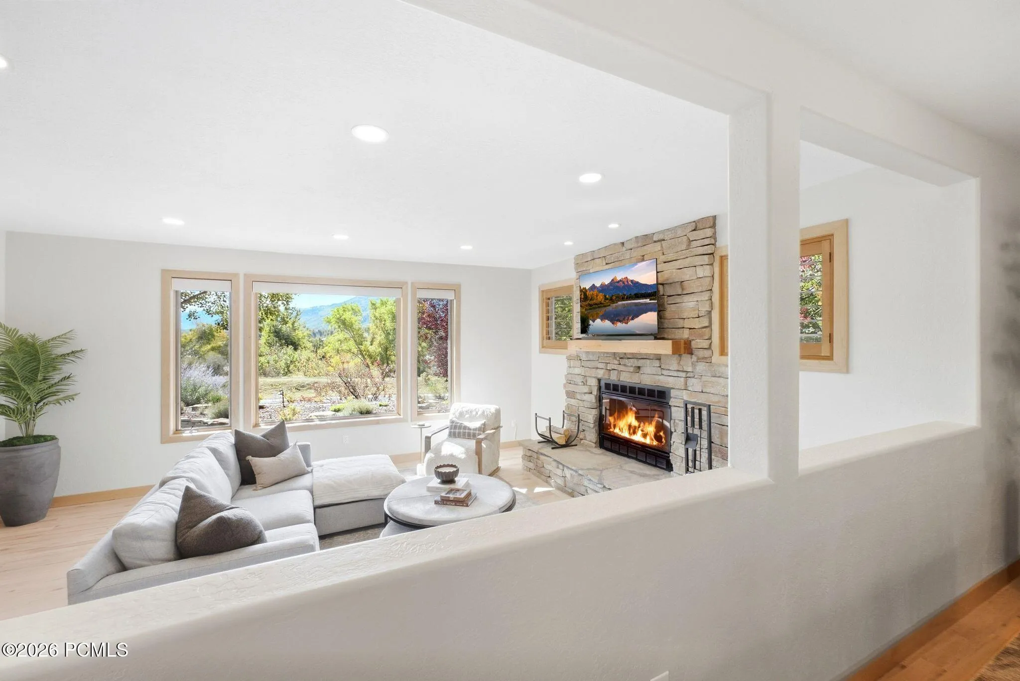 Open concept kitchen, dining, and living area. Refinished wood flooring throughout, updated lighting, wood-framed windows with wooden shutters, natural light and views.
