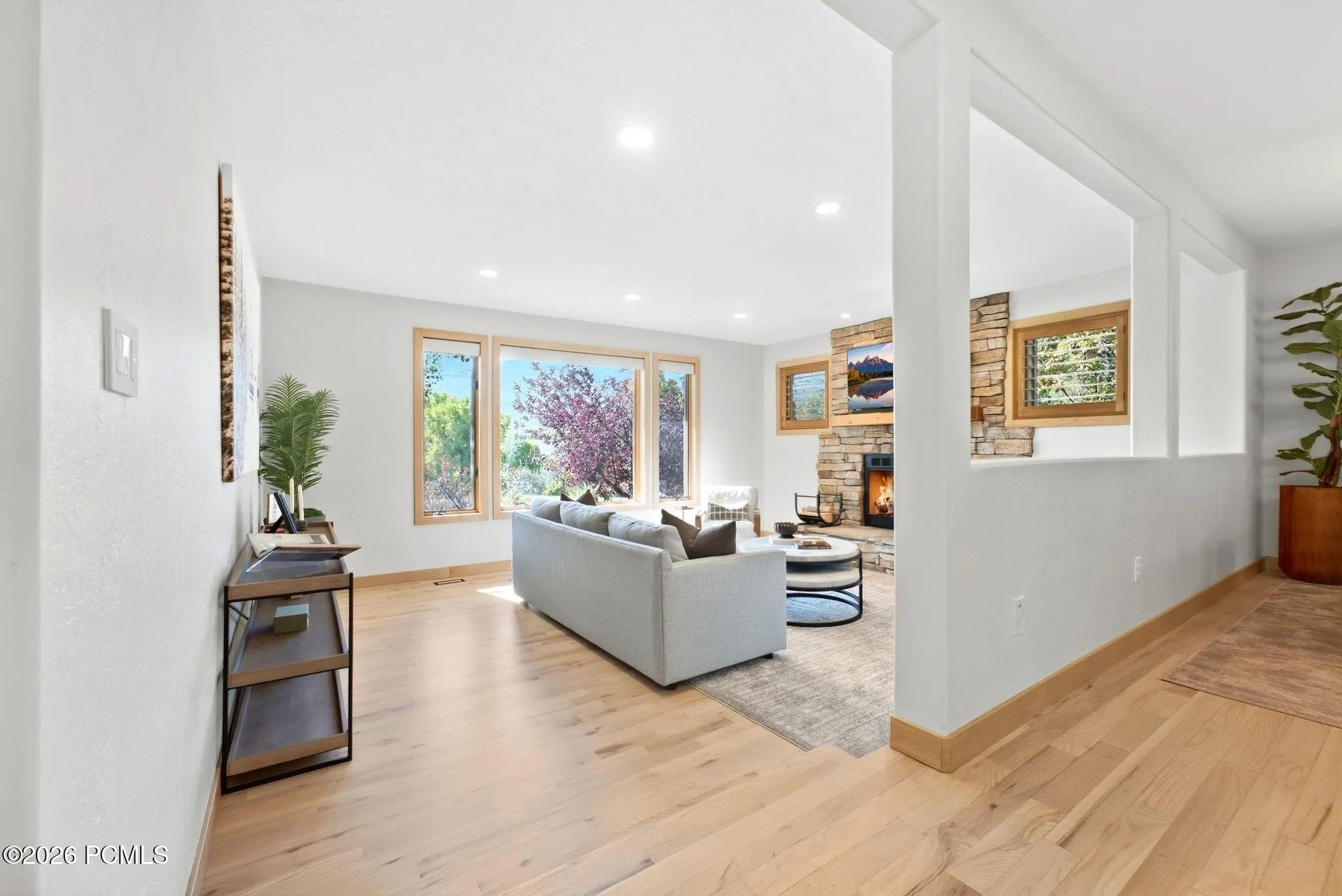 Open concept kitchen, dining, and living area. Refinished wood flooring throughout, updated lighting, wood-framed windows with wooden shutters, natural light and views.