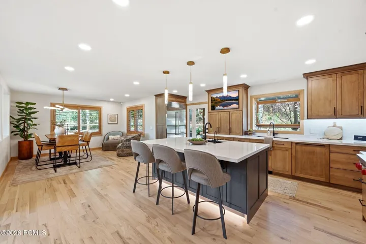 Open-concept kitchen and dining area with ample natural light. Refinished wood flooring, updated lighting.