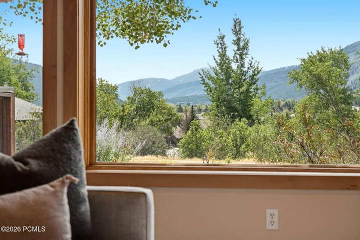 Large picture window with natural wood trim framing a mountain your views of Park City. You can see fireworks from the Canyons Village and Park City mountain resorts without ever leaving your living room or front porch!