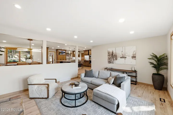 Open-concept living area featuring refinished hardwood flooring, updated recessed ceiling lighting, with ample natural light and a picture window that brings Park City into your living room.