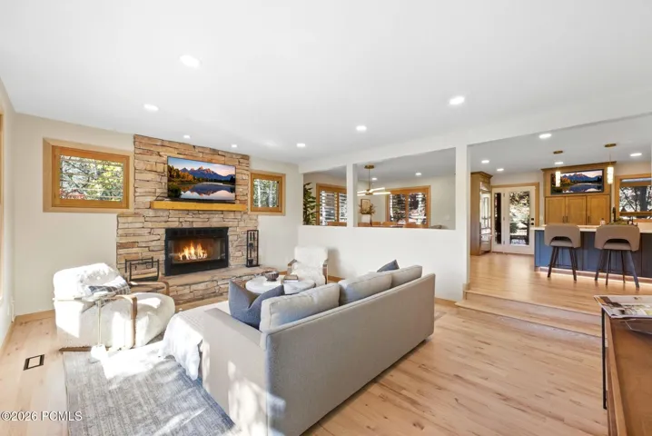Open-concept living area featuring refinished hardwood flooring, updated recessed ceiling lighting, with ample natural light and a picture window that brings Park City into your living room.