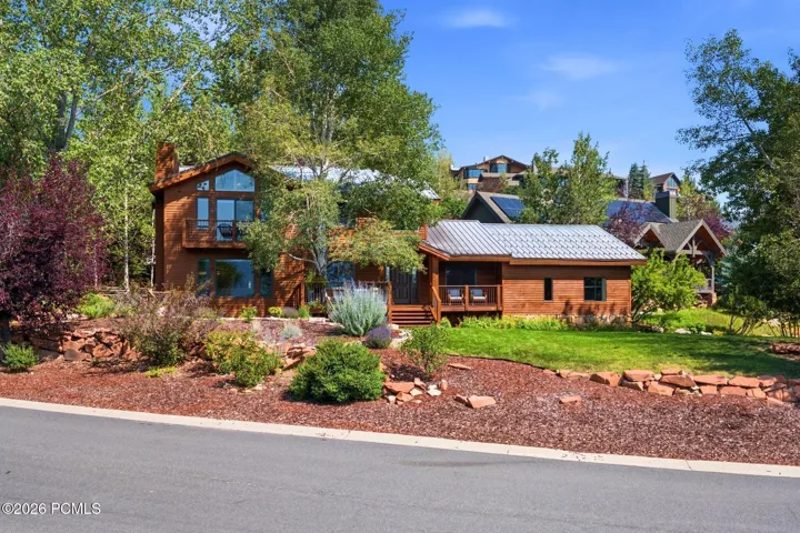 Front view of 1936 Kidd Cir. with tastefully done xeriscaping and a nice grassy area with mature trees.