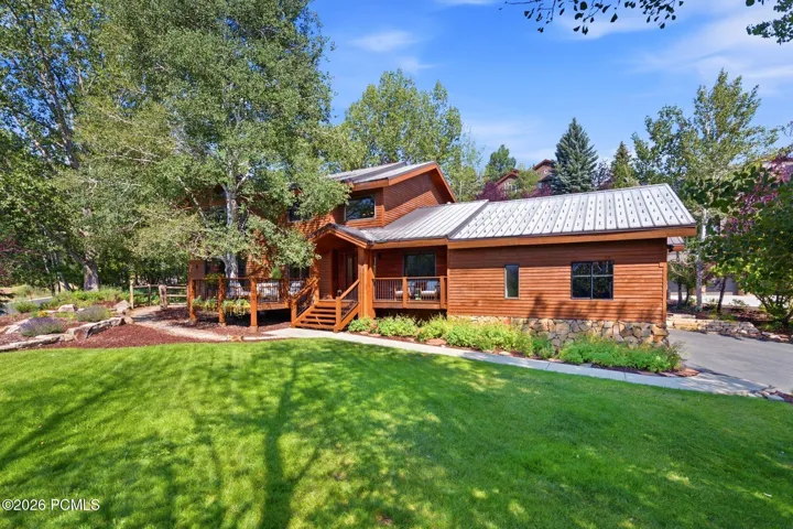Front view of 1936 Kidd Cir. with tastefully done xeriscaping and a nice grassy area with mature trees.