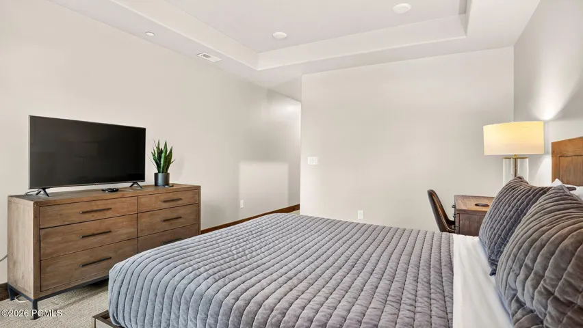 Primary bedroom with dresser and mounted TV - Deer Park 102, Jordanelle, Heber City UT