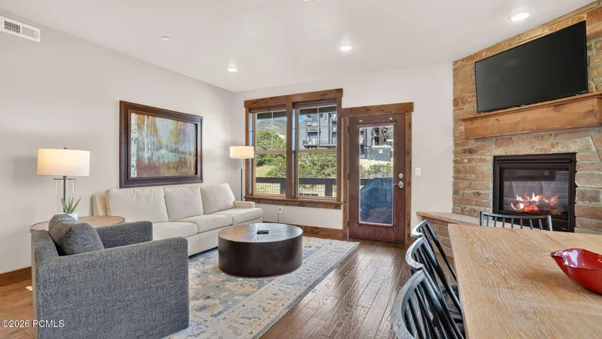 Great room with stone fireplace and mountain window walls - Deer Park 102, Jordanelle, Heber City UT