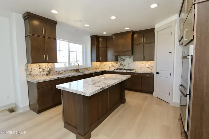 Kitchen with island, double wall ovens, gas counter-top range, microwave & walk-in pantry.