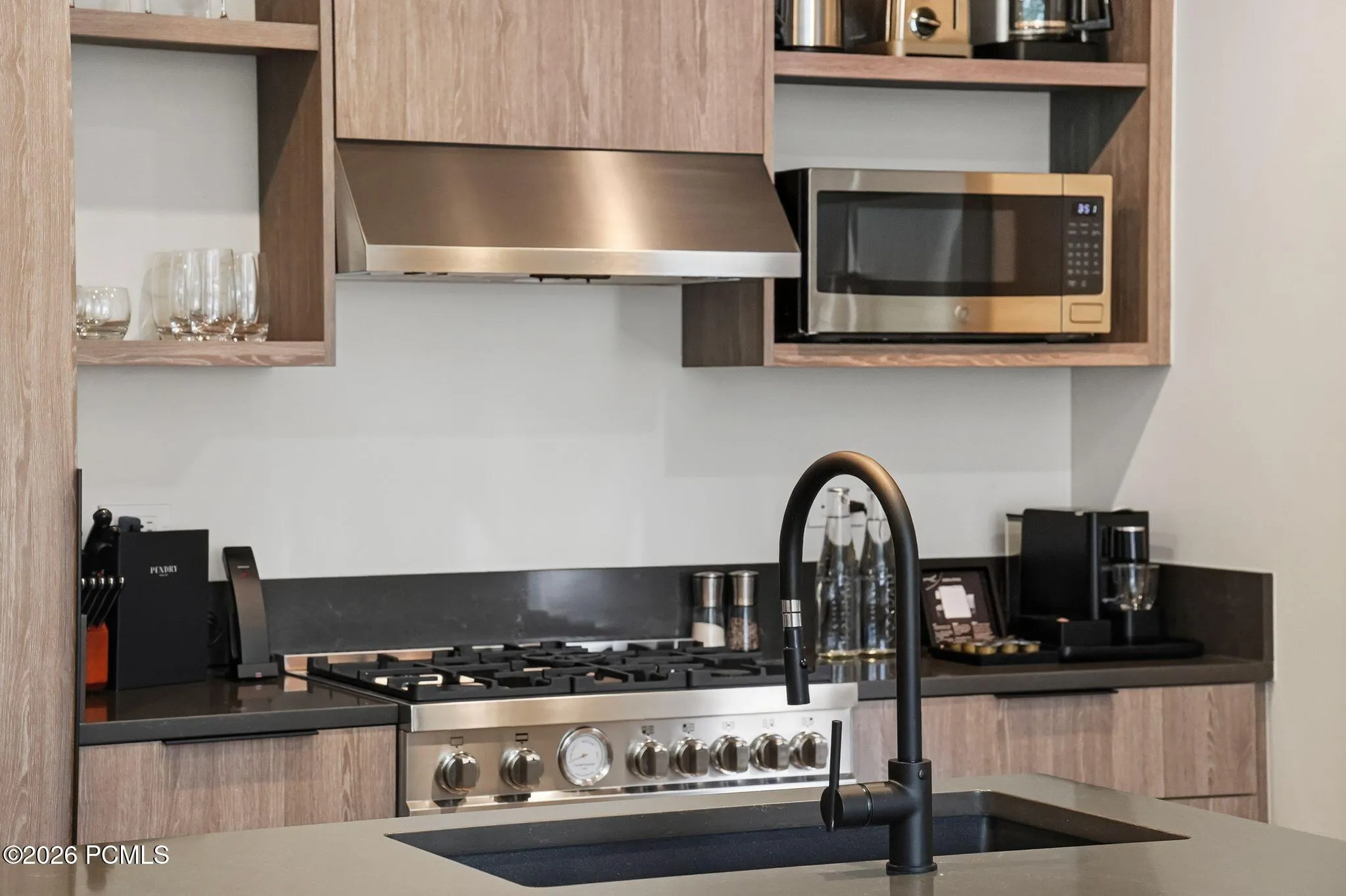 Gas range, vent hood and built in microwave in the Pendry Park City kitchen.