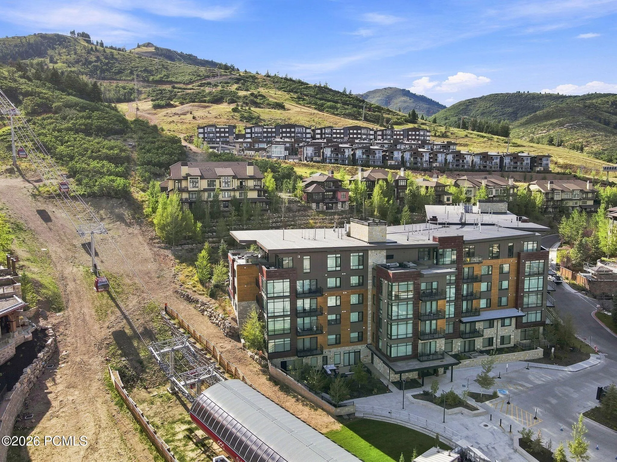 Aerial showing Pendry Residences Park City and the Canyons Village ski runs above.