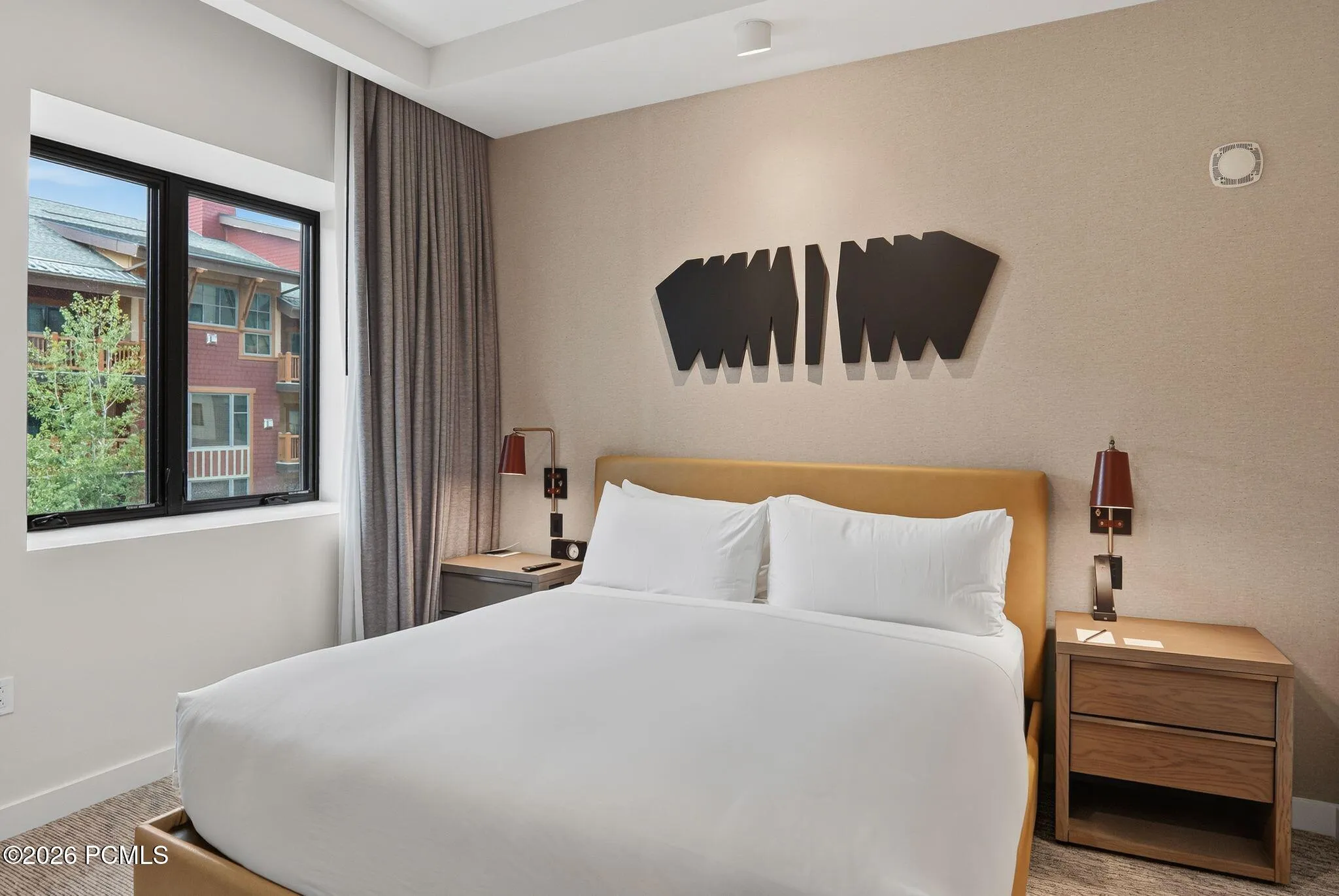 Primary bedroom king suite with custom headboard wall and mountain light at Pendry Park City.