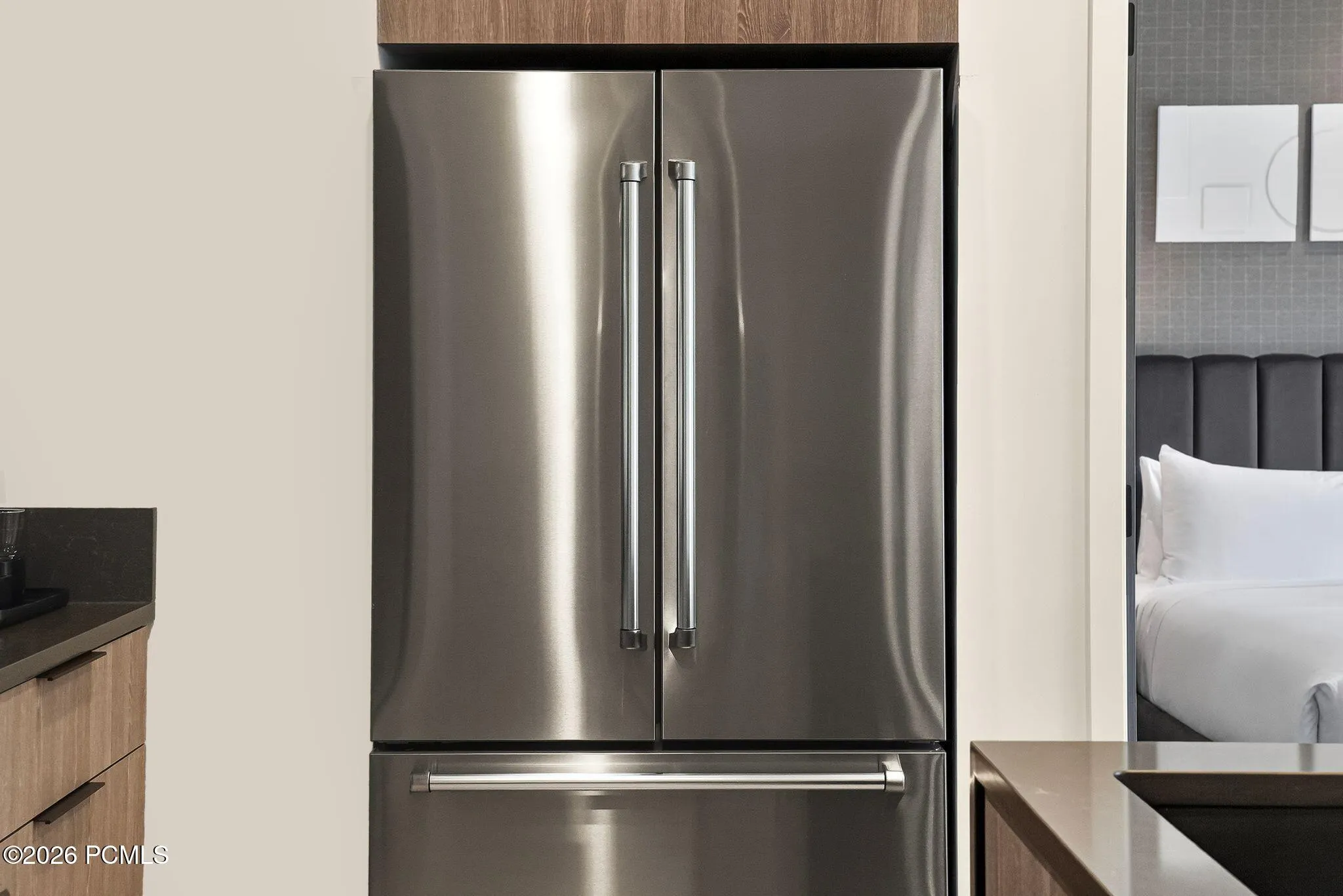 Full size stainless refrigerator and kitchen storage in the residence.