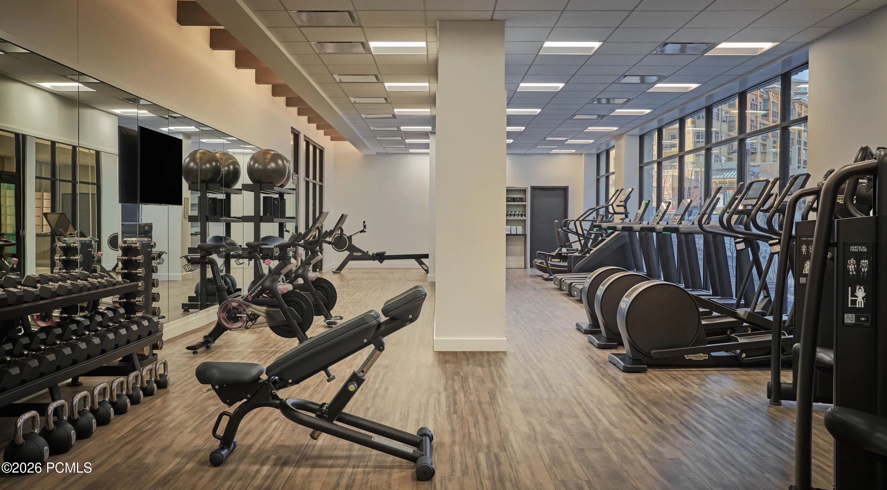 Fitness center at Pendry Park City with free weights, strength equipment and cardio overlooking Canyons Village.