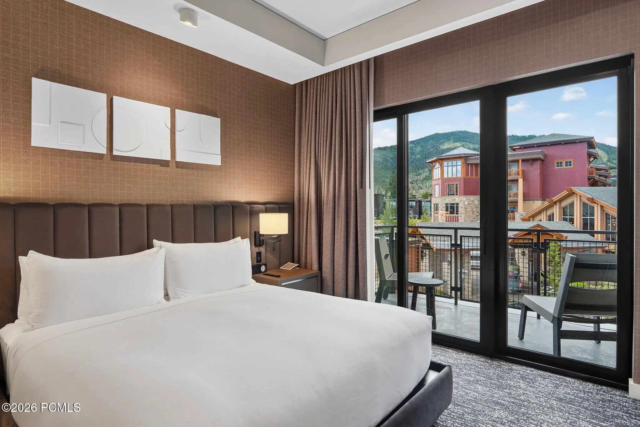 Primary bedroom with a sliding door to the private balcony and Canyons Village mountain views.