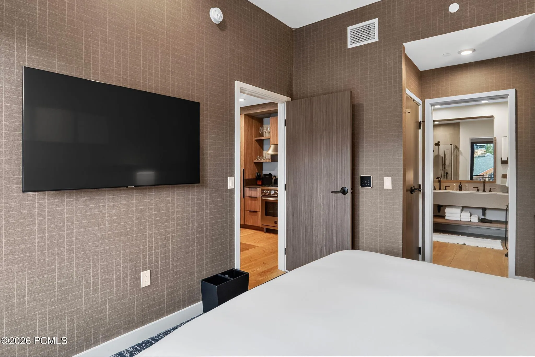 Guest bedroom with a mounted television and direct access to the bath.