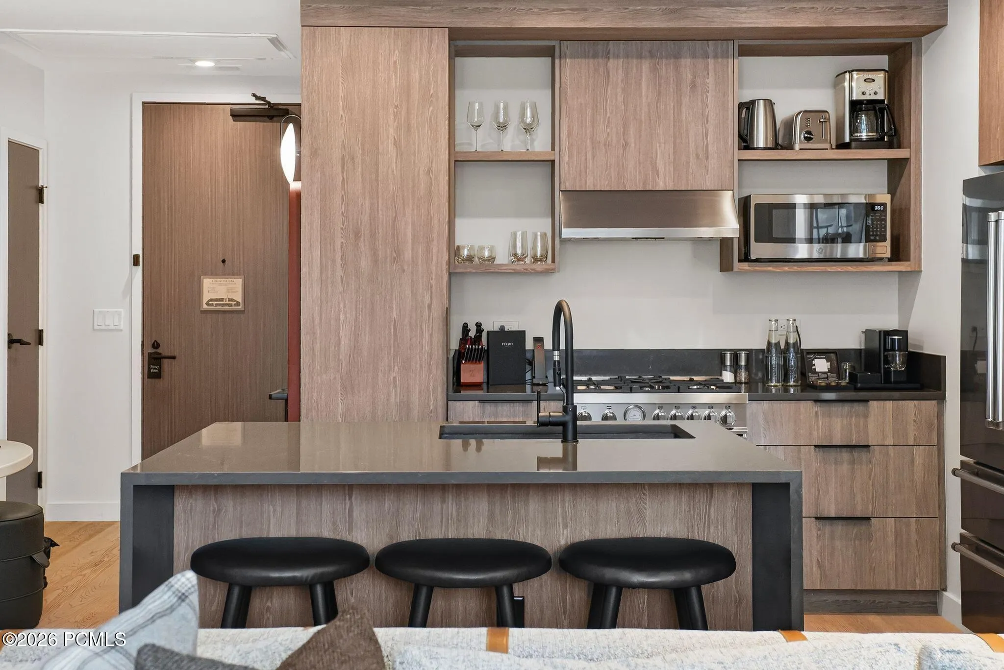 Kitchen island seats three, with integrated appliances and custom cabinetry throughout.