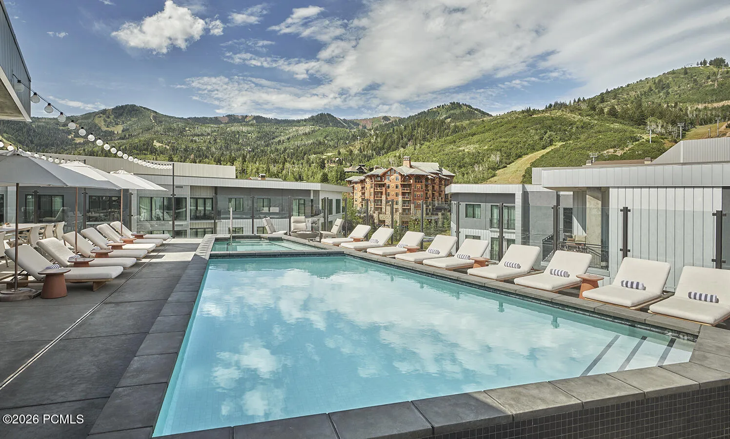 Outdoor pool and lounge deck at Pendry Park City with Canyons Village ski terrain as the backdrop.