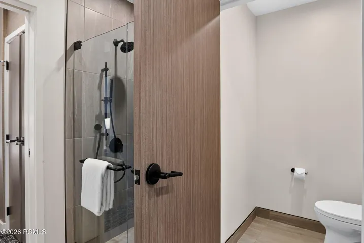 Guest bath walk in shower with wood detailing and matte black fixtures at Pendry Park City.