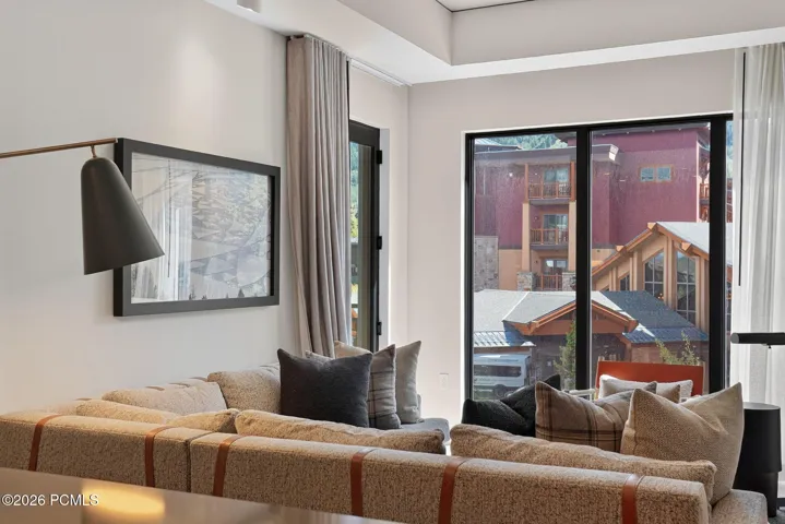 Living area opens through a sliding glass door to the private deck and Canyons Village views.