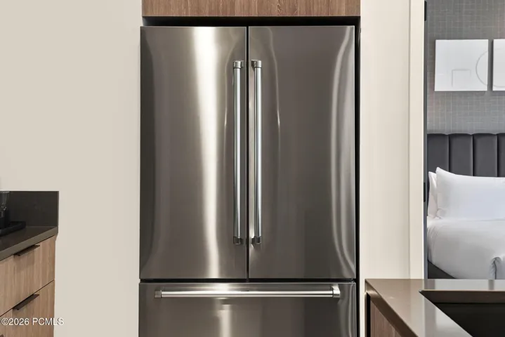 Full size stainless refrigerator and kitchen storage in the residence.