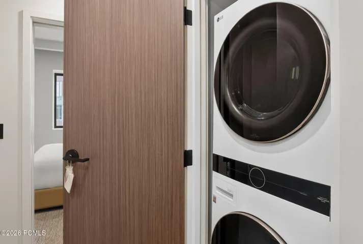 Full size stacked washer and dryer inside the residence.