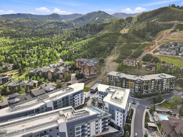 Aerial of Pendry Residences Park City with Canyons Village ski terrain rising behind the building.