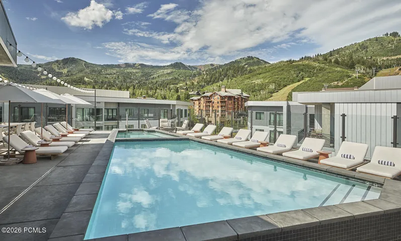 Outdoor pool and lounge deck at Pendry Park City with Canyons Village ski terrain as the backdrop.