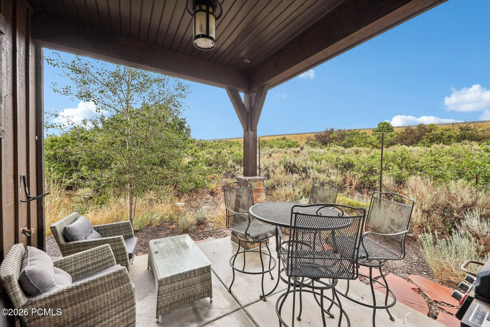 Covered lower patio opening to open sage and an unobstructed ridgeline with no rear neighbors in Hideout, Utah.