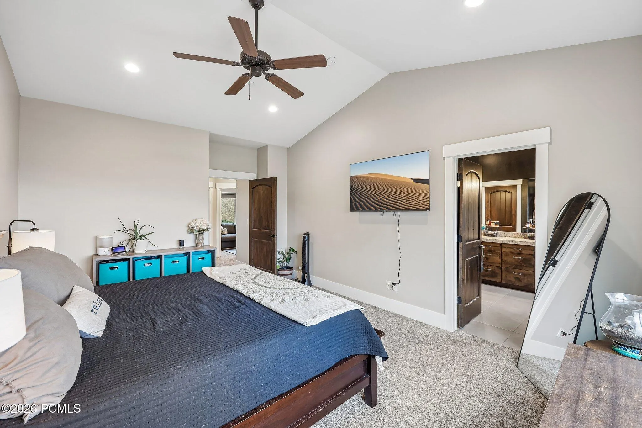 Primary suite with a vaulted ceiling, ensuite bathroom and walk-in closet opening off the room in a Hideout, Utah home.