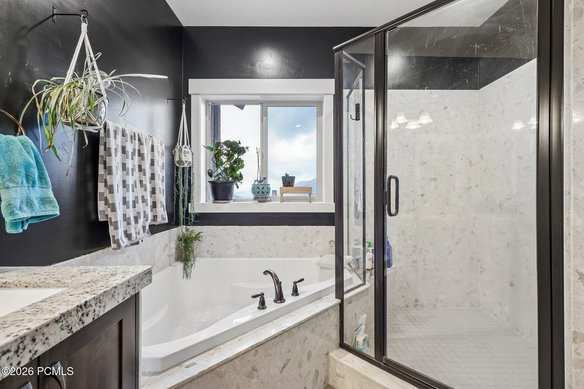 Primary bathroom with a soaking tub, separate glass shower and window above the tub, in a Hideout, Utah home near Jordanelle Reservoir.