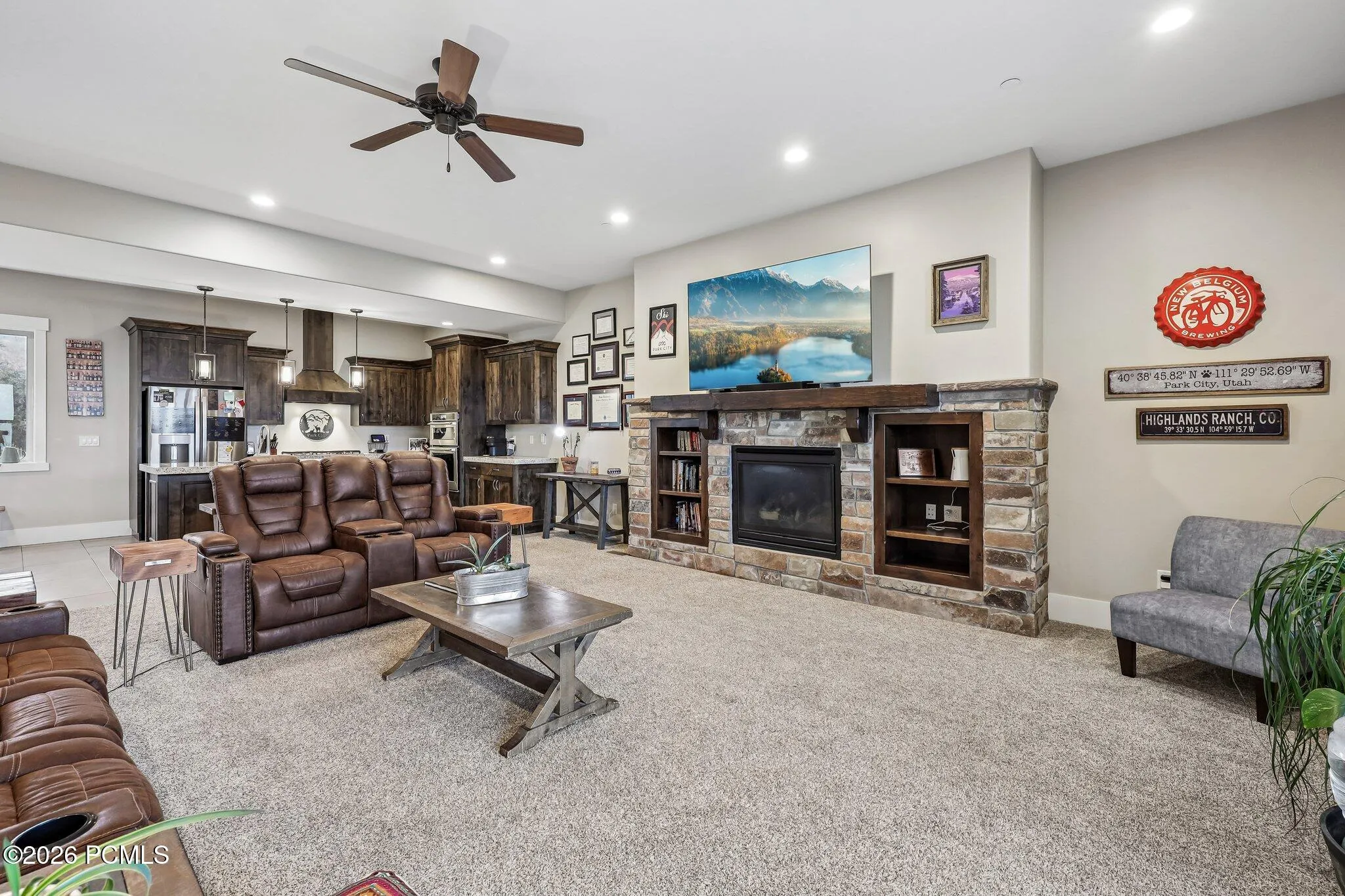 Wide-angle view of the main level showing the stone fireplace, kitchen and dining area in one open floor plan in a Rustler at Hideout home.