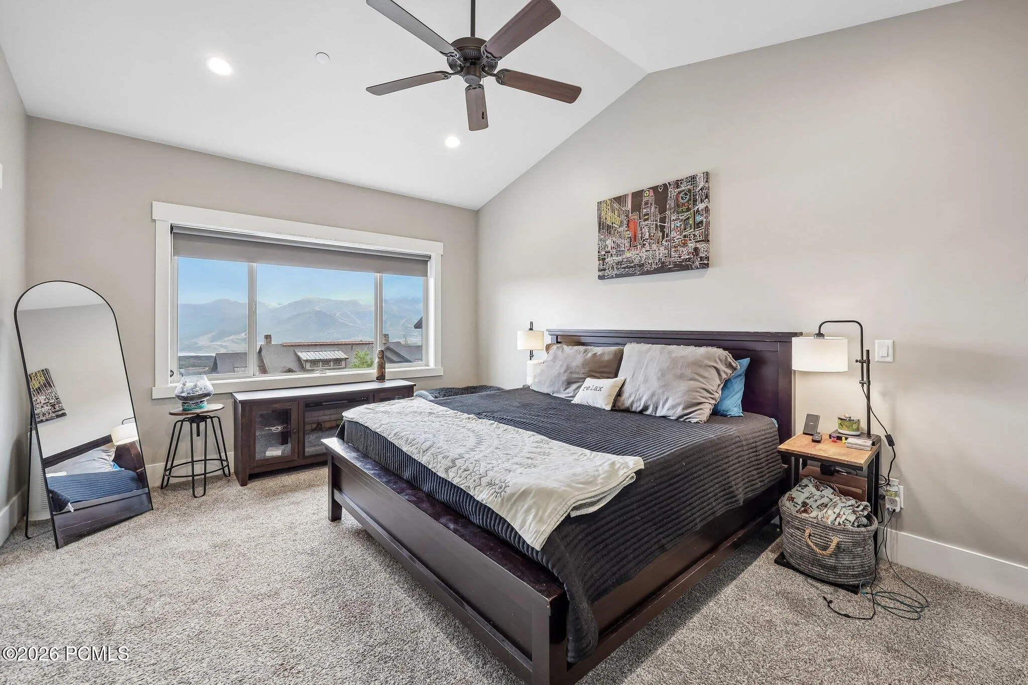 Primary bedroom with a vaulted ceiling, king bed and picture window framing Jordanelle Reservoir and open Wasatch Back country.