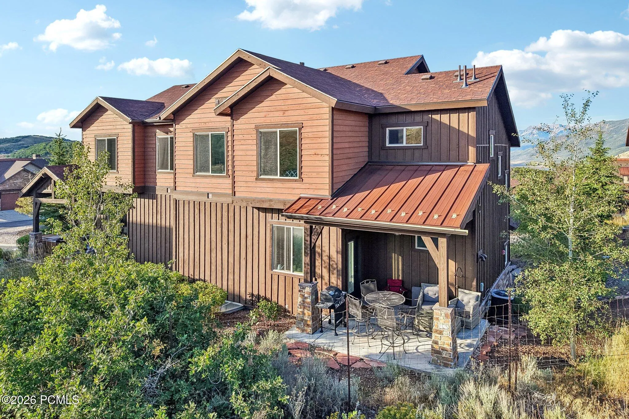 Front elevation with cedar siding, metal roof accents and established low-maintenance landscaping in Rustler at Hideout, Hideout, Utah.