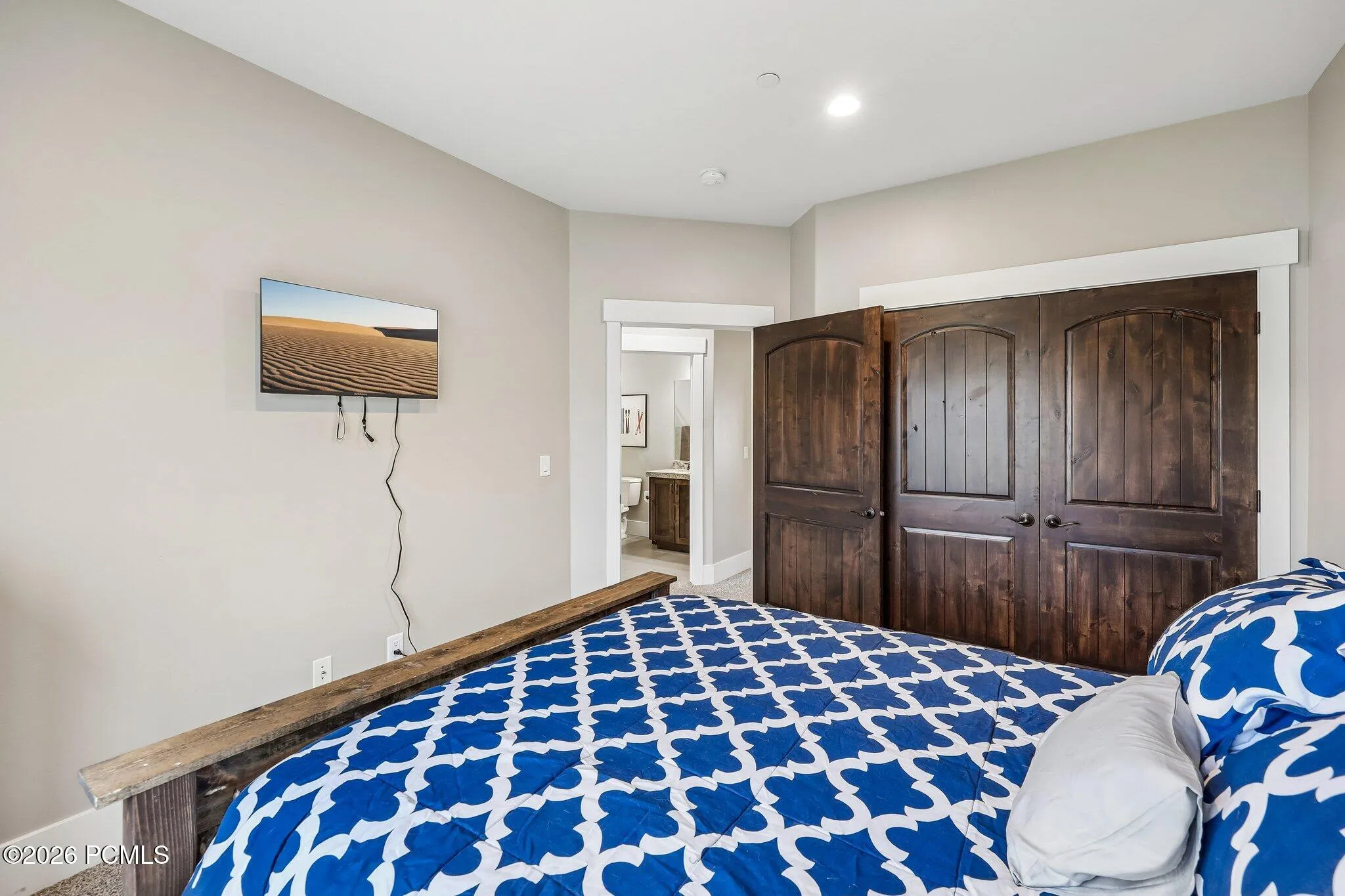 Upstairs guest bedroom with a double-door closet, carpeted floors and hall bath access in a Hideout, Utah home near Jordanelle Reservoir.