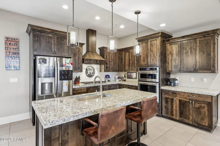 Kitchen with stainless steel appliances, a built-in wall oven and a walk-in pantry in a Hideout, Utah mountain home.